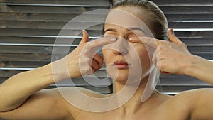 Woman doing face fitness, aging chang in the muscles of the face. strengthening of the upper and lower eyelid