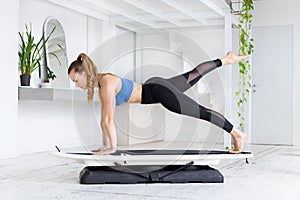 Woman doing a fit surf plank kick back