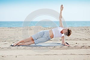 Woman doing fitness exercise on beach