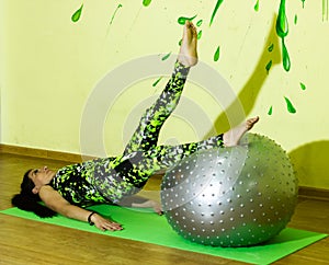 Woman doing fitness exercise, young woman doing fitness exercises with fitness ball in fitness club