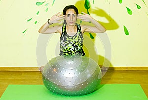 Woman doing fitness exercise, young woman doing fitness exercises with fitness ball in fitness club