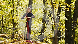 Woman doing fitness exercises outdoor. Female stretching in autumn forest. Slim girl at workout