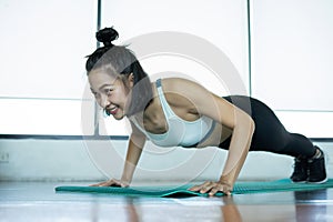 Woman doing fitness training. Fitness woman doing push ups on a training mat. young woman doing push-ups at the gym. Muscular