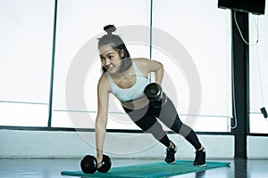 Woman doing fitness training. Fitness woman doing push ups on a training mat. young woman doing push-ups at the gym. Muscular