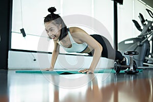 Woman doing fitness training. Fitness woman doing push ups on a training mat. young woman doing push-ups at the gym. Muscular