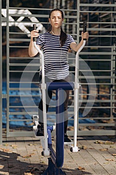 Woman doing fitness training at the outdoor gym in park. Athletic and fitness training outdoors. Active lifestyle and