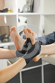 Woman doing foot peeling in pedicure SPA salon. Sugar scrub and relax beauty procedure