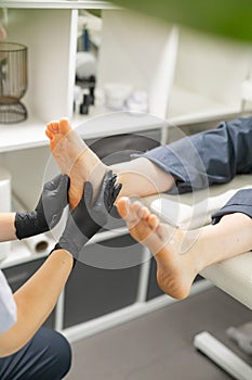 Woman doing foot peeling in pedicure SPA salon. Sugar scrub and relax beauty procedure