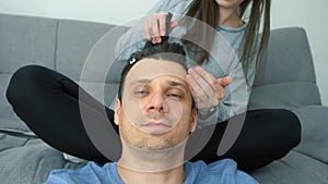 Woman is doing french braid on short men's hair, closeup head view.