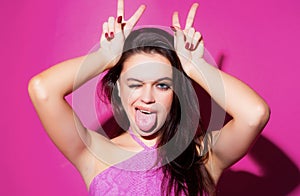 Woman doing funny gesture with finger over head as bull horns. Crazy funny sexy girl doing funny gesture with finger