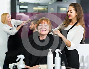 Woman doing haircut with girl hairstylist