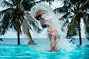 woman doing hairflip in swimming pool