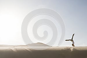 Woman doing handstand in desert