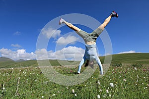 Woman doing a handstand in a mountain peak