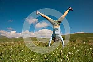 Woman doing a handstand in a mountain peak