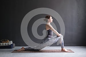 Woman doing Hatha yoga asana Anjaneyasana or low crescent lunge pose isolated,