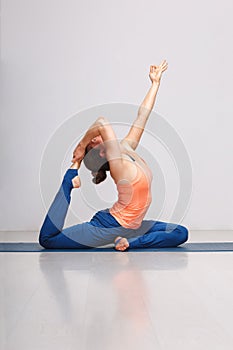 Woman doing Hatha yoga asana Eka pada rajakapotasana