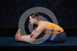 Woman doing Hatha yoga Ashtanga Vinyasa yoga asana Paschimottana