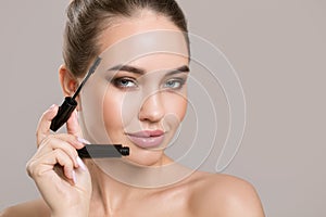 Woman doing her makeup eyelashes black mascara