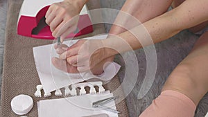 Woman is doing herself pedicure at home