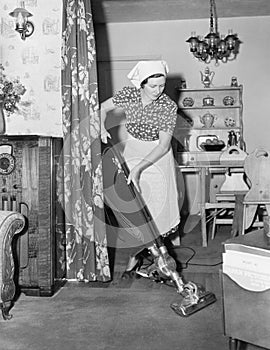 Woman doing housework with a vacuum cleaner photo