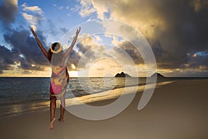 Woman doing hula at sunrise at lanikai