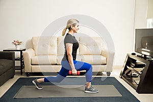 Woman doing kneeling lunges at home