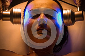 Woman doing LED face therapy in blue