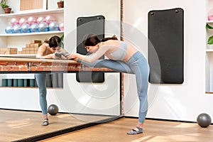 Woman doing leg stretching exercises in a barre