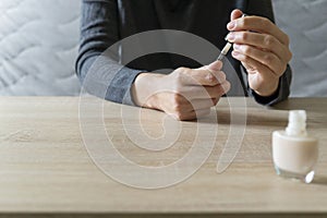 Woman doing the manicure. Removing the polish and putting on the cream. Woman that care his hands. Style concept