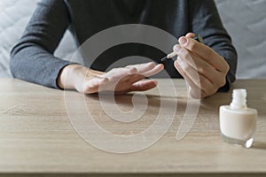 Woman doing the manicure. Removing the polish and putting on the cream. Woman that care his hands. Style concept