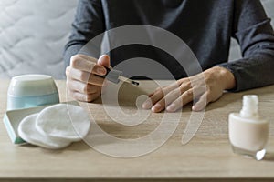 Woman doing the manicure. Removing the polish and putting on the cream. Woman that care his hands. Style concept