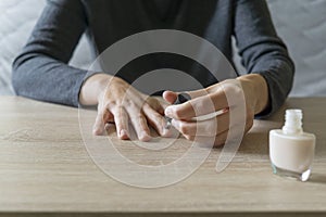 Woman doing the manicure. Removing the polish and putting on the cream. Woman that care his hands. Style concept