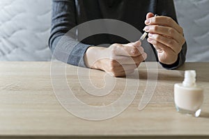 Woman doing the manicure. Removing the polish and putting on the cream. Woman that care his hands. Style concept