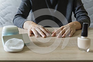 Woman doing the manicure. Removing the polish and putting on the cream. Woman that care his hands. Style concept