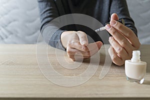 Woman doing the manicure. Removing the polish and putting on the cream. Woman that care his hands. Style concept