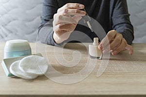 Woman doing the manicure. Removing the polish and putting on the cream. Woman that care his hands. Style concept