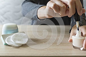 Woman doing the manicure. Removing the polish and putting on the cream. Woman that care his hands. Style concept