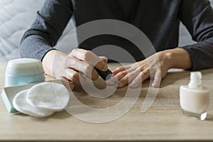 Woman doing the manicure. Removing the polish and putting on the cream. Woman that care his hands. Style concept