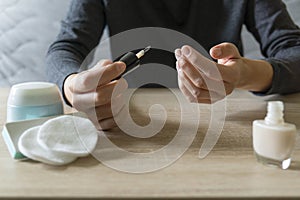 Woman doing the manicure. Removing the polish and putting on the cream. Woman that care his hands. Style concept