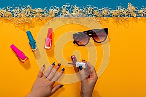 Woman doing manicures with different nail polishes summer vibrant colors.