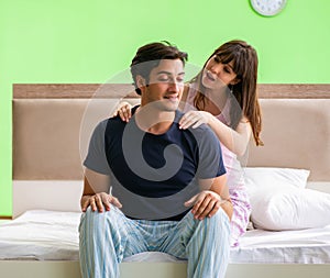 Woman doing massage to her husband in bedroom