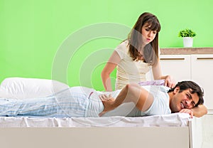 Woman doing massage to her husband in bedroom