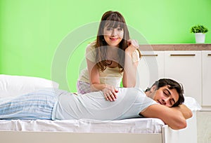 Woman doing massage to her husband in bedroom