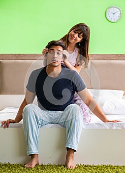 Woman doing massage to her husband in bedroom