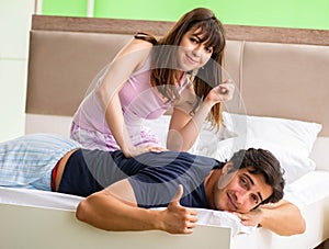 Woman doing massage to her husband in bedroom