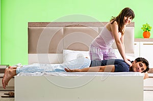 Woman doing massage to her husband in bedroom