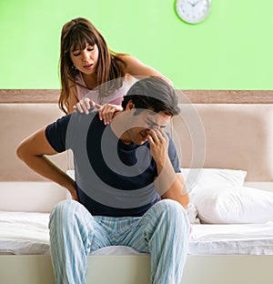 Woman doing massage to her husband in bedroom