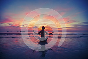 Woman doing meditation near the ocean beach.