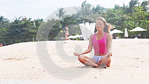 Woman doing meditation near the ocean beach. Yoga silhouette.